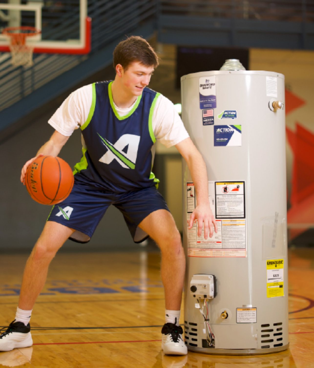 Pryce Sandfort posing with a water heater on the basketball court — his biggest paid NIL post